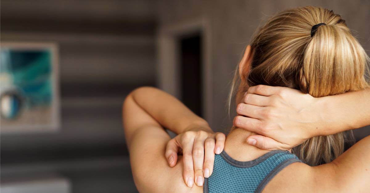 A woman with her hands on her neck and shoulders. She has blond hair with a ponytail and the background is blurred. Best Foods That Help With Injury Recovery