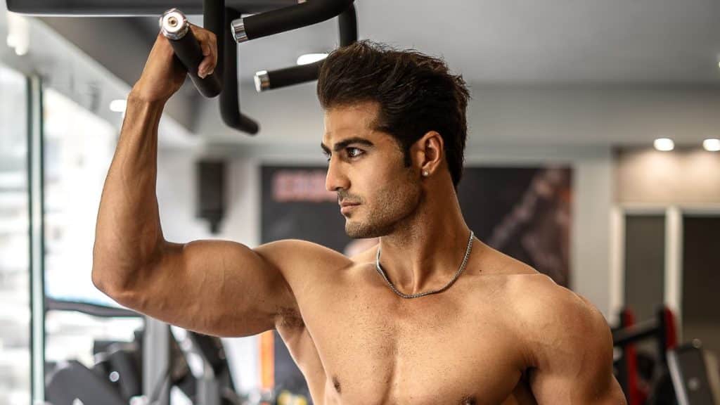 Young Muscular Man Standing Shirtless at the Gym